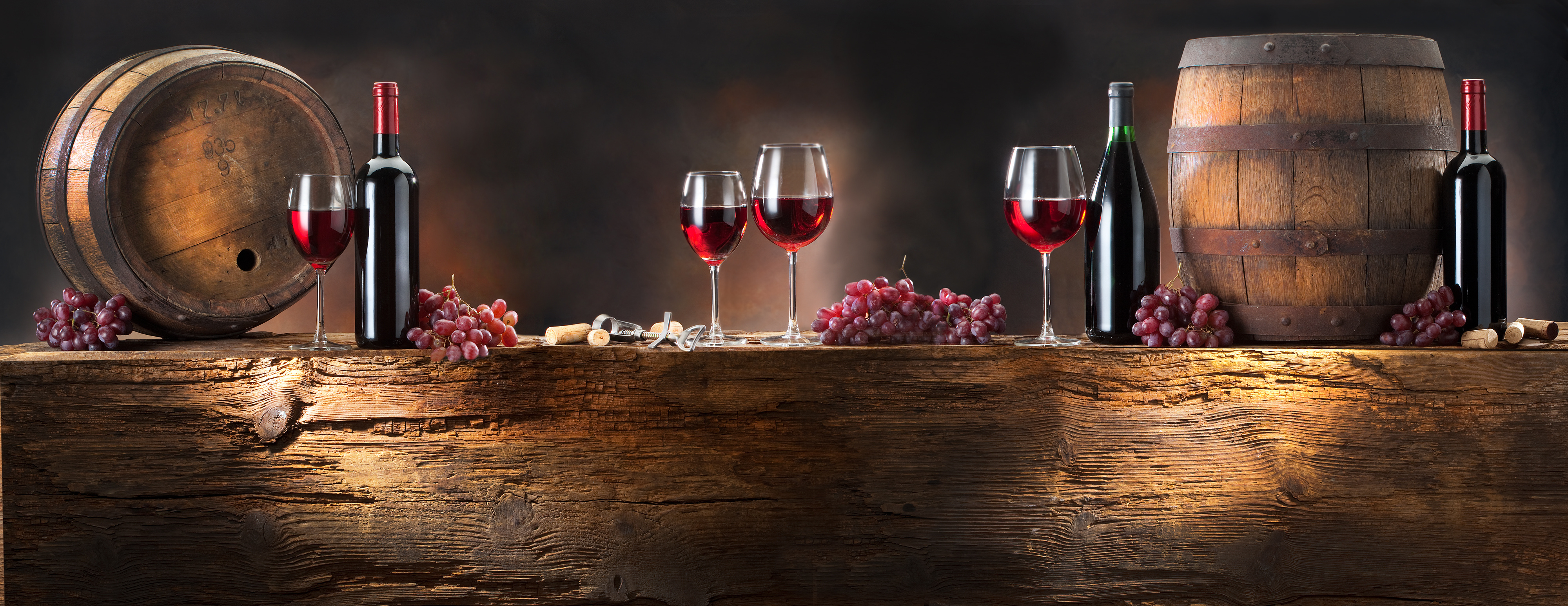 still life with red wine with barrel on old wood